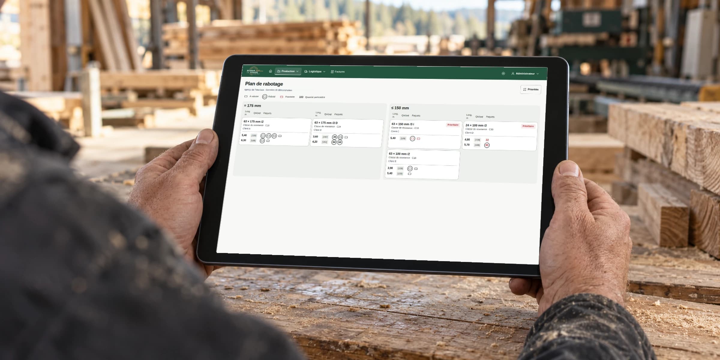 Illustrative scene of a worker with the Scierie de Graide planing schedule on a tablet, using demo data